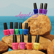 Collection of OPI nail polish bottles on rocks with a blue ocean background